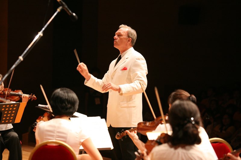 David Eaton conducting, with a violinist in the foreground